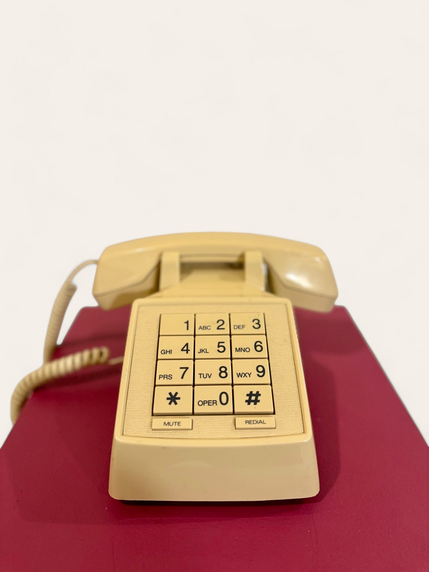A retro rotary dial telephone sits on a wooden desk with intricate designs, evoking a sense of A retro rotary dial telephone sits on a wooden desk with intricate designs, evoking a sense of